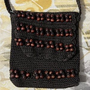 Brown, tight crochet purse with wood bead accents. Lined inside, zip closer